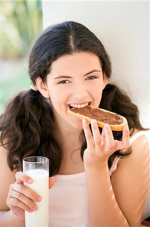 Woman eating a chocolate toast Stock Photo - Rights-Managed, Code: 877-08026465