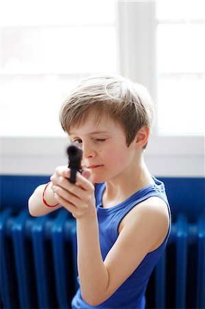 pictures of pre teen boys in tank tops - A boy playing with a gun toy Stock Photo - Rights-Managed, Code: 877-08031253