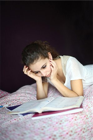 purple science - A teenage girl doing homework on her bed Stock Photo - Rights-Managed, Code: 877-08031278