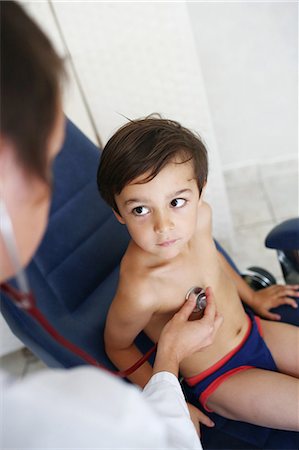 Doctor examining young patient, using stethoscope Foto de stock - Con derechos protegidos, Código: 877-08031333