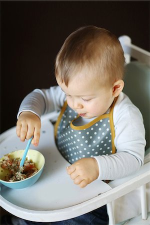 A 15 months baby boy eating on his high chair Stock Photo - Rights-Managed, Code: 877-08079123