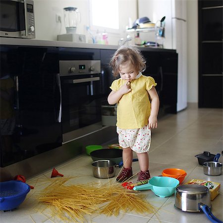 A 2 years old little girl posing in a kitchen in which she made the mess Stockbilder - Lizenzpflichtiges, Bildnummer: 877-08079192