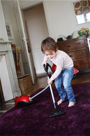 Little boy using vacuum cleaner Foto de stock - Con derechos protegidos, Código: 877-08079247