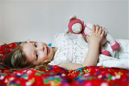 dummy (pacifier) - Portrait of a 3 years old girl on her bed with her doll Foto de stock - Con derechos protegidos, Código: 877-08127968