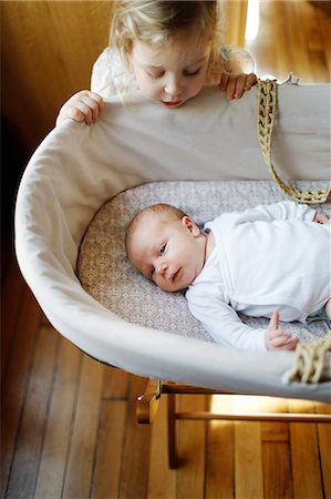 female body lying down - A 3 years old girl looking at her little brother in his crib Photographie de stock - Rights-Managed, Code: 877-08127976