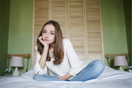 simsearch:877-08079201,k - A teenage girl looks dreamy sitting on her bed Foto de stock - Con derechos protegidos, Código: 877-08128015