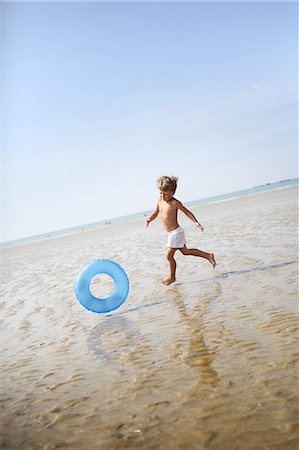 Little boy at the beach with his rubber ring Foto de stock - Con derechos protegidos, Código: 877-08128122