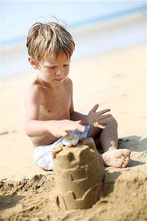 Little boy making a sand castle on the beach Stock Photo - Rights-Managed, Code: 877-08128130