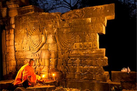 ruins people - Camdodia, Banteay Mean Chey Province, Banteay Chhmar temples, Site World Heritage of Humanity by Unesco in 1992, Banteay Chhmar temple, the monk Chean Som praying in front of Avalokiteshvara, a major character of Buddhism Stock Photo - Rights-Managed, Code: 877-08128284