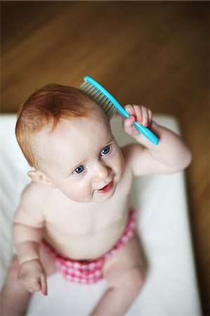 A 9 months baby girl brushes her hair Foto de stock - Con derechos protegidos, Código: 877-08129030