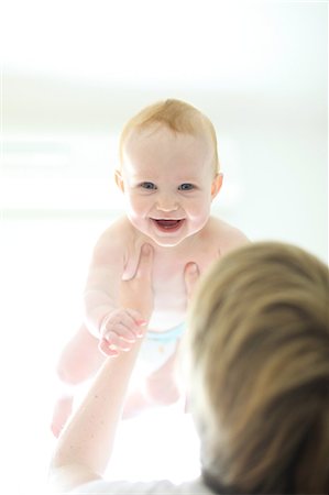 diapering mother to baby - Woman holding baby up Photographie de stock - Rights-Managed, Code: 877-08129033