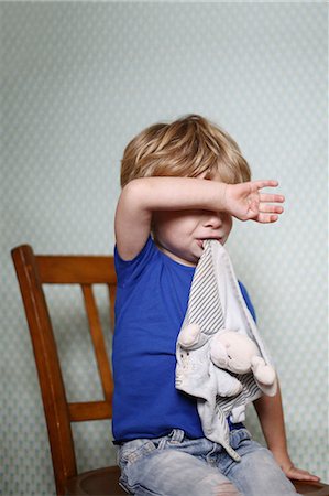 Little boy sitting on a chair sulking Stock Photo - Rights-Managed, Code: 877-08129135