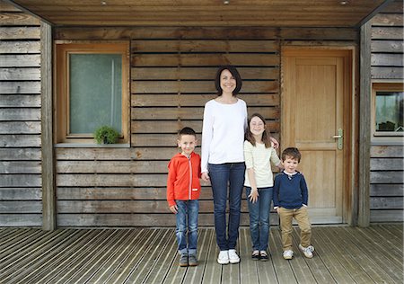 A mother and her three children at the front door of their house Foto de stock - Con derechos protegidos, Código: 877-08129226