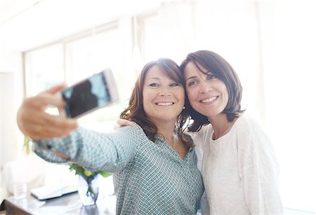 2 friends photographing themselves with a smartphone Stockbilder - Lizenzpflichtiges, Bildnummer: 877-08129243