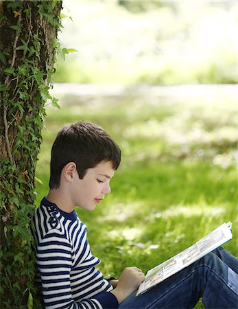 simsearch:877-08129368,k - A 9 years old boy reading a book in the countryside Photographie de stock - Rights-Managed, Code: 877-08129365