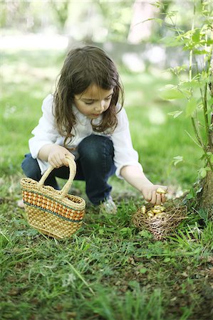 easter people - A 5 years old girl picking up Easter eggs in the countryside Stock Photo - Rights-Managed, Code: 877-08129382
