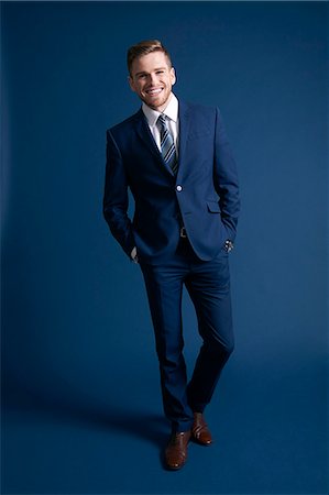 studio photography background - man in blue suit, blue background, watch, smiling, tie Photographie de stock - Rights-Managed, Code: 877-08129436