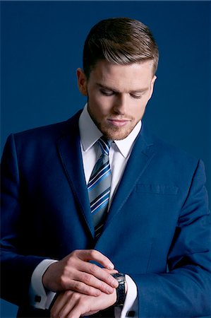 man in blue suit, glasses, blue background, watch Stockbilder - Lizenzpflichtiges, Bildnummer: 877-08129444