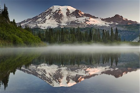 simsearch:6118-07354298,k - Mount Rainier, a snow capped peak, surrounded by forest reflected in one of many lakes in the Mount Rainier National Park. Foto de stock - Con derechos protegidos, Código: 878-07442782