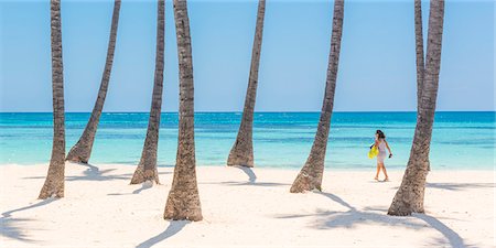 simsearch:6129-09044541,k - Juanillo Beach (playa Juanillo), Punta Cana, Dominican Republic. Woman walking on the palm-fringed beach (MR). Foto de stock - Direito Controlado, Número: 879-09021018