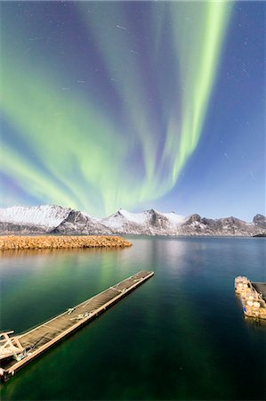 Northern lights on snowy peaks and icy sea along Mefjorden seen from the village of Mefjordvaer Senja Tromsø Norway Europe Photographie de stock - Rights-Managed, Code: 879-09021224