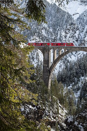 simsearch:879-09033219,k - The red train on the Wiesener Viadukt surrounded by woods. Engadine. Canton of Graubuenden. Switzerland. Europe. Photographie de stock - Rights-Managed, Code: 879-09034031