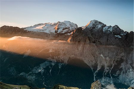 The orange light beam frames the snowy peaks of Marmolada at dawn Cima Belvedere Val di Fassa Trentino Alto Adige Italy Europe Photographie de stock - Rights-Managed, Code: 879-09034278