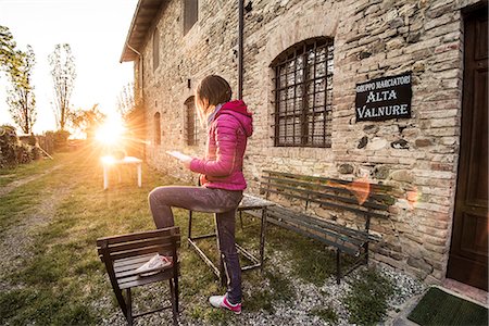 simsearch:879-09034416,k - Grazzano Visconti, Vigolzone, Piacenza district, Emilia Romagna, Italy. Woman reading on a chair in a old couryard of the town. Foto de stock - Con derechos protegidos, Código: 879-09033534