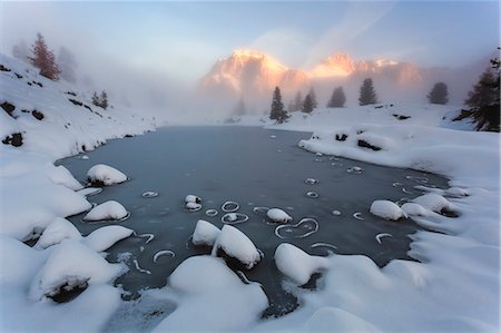 The Limedes alpine lake covered by a thin layer of ice in an autumn sunrise. Belluno, Veneto, Italy Stock Photo - Rights-Managed, Code: 879-09033671