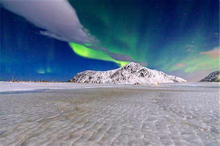 Northern Lights illuminate the sky and the snowy peaks. Flakstad. Lofoten Islands Northern Norway Europe Stock Photo - Rights-Managed, Code: 879-09043834