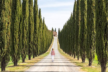 simsearch:879-09191594,k - Castiglione d'Orcia, Orcia valley, Siena, Tuscany, Italy. A young woman in casual clothes is walking along a country road Stock Photo - Rights-Managed, Code: 879-09099974