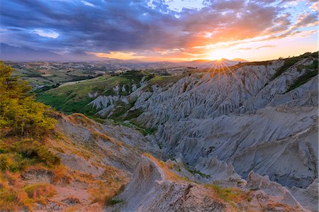 simsearch:879-09100423,k - Sun filters through the clouds during sunset illuminating the Calanchi of Atri, Abruzzo, Italy. Stock Photo - Rights-Managed, Code: 879-09100160