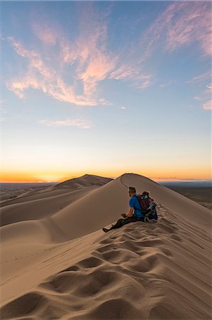 Man watching the sunset in Gobi Gurvan Saikhan National Park. Sevrei district, South Gobi province, Mongolia. Stock Photo - Rights-Managed, Code: 879-09100263