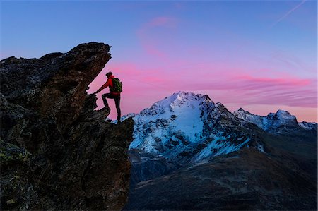 simsearch:879-09100329,k - An hiker climbing a rock in Viola valley with a panoramic view at sunset. Valdidentro, Valtellina, Lombardy, Italy Fotografie stock - Rights-Managed, Codice: 879-09100357