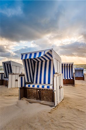 Kampen, Sylt island, North Frisia, Schleswig-Holstein, Germany. Strandkorbs on the beach at sunset. Foto de stock - Con derechos protegidos, Código: 879-09100429