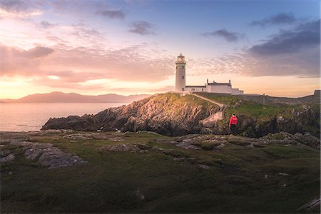 simsearch:6129-09044479,k - Fanad Head (Fánaid) lighthouse, County Donegal, Ulster region, Ireland, Europe. A photographer on the field at sunrise near Fanad Head lighthouse Foto de stock - Con derechos protegidos, Código: 879-09128812