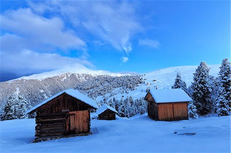 Old snow-covered huts during twilight. Erbe Pass, Funes Valley, South Tyrol, Dolomites, Italy Foto de stock - Con derechos protegidos, Código: 879-09128879