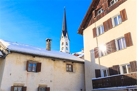 simsearch:879-09129263,k - Tower bell of the church of Zuoz with sun reflected in a window. Zuoz, Engadine, Graubünden, Switzerland. Photographie de stock - Rights-Managed, Code: 879-09128900