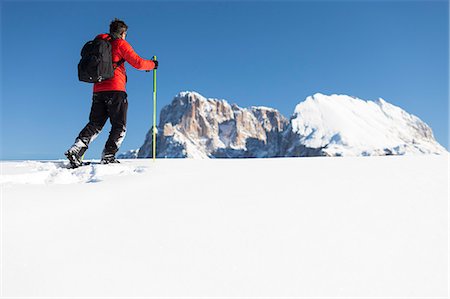 plattkofel - a hiker is trekking with snowshoes on the Seiseralm with Langkofel and Plattkofel in the background, Bolzano province, South Tyrol, Trentino Alto Adige, Italy Stockbilder - Lizenzpflichtiges, Bildnummer: 879-09129050