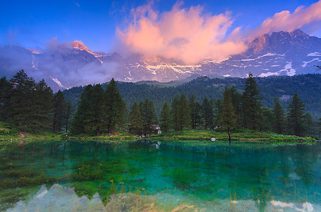 see (der) - Cloud illuminated by the colors of dawn is reflected in Blue Lake. Blu Lake, Cervinia, Valtournanche, Aosta valley, Italy, Europe Stockbilder - Lizenzpflichtiges, Bildnummer: 879-09189680