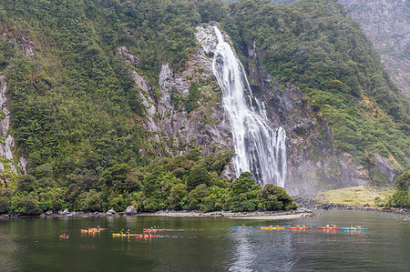 People kayaking around Bowen Falls in Milford Sound in summer. Fiordland NP, Southland district, Southland region, South Island, New Zealand. Foto de stock - Con derechos protegidos, Código: 879-09189995