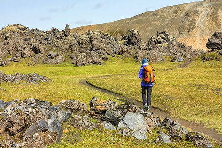 Graenagil footpath: a trekker is walking through the Laugahraun lava field in Landmannalaugar (Fjallabak Nature Reserve, Highlands, Southern Region, Iceland, Europe) (MR) Foto de stock - Direito Controlado, Número: 879-09190330