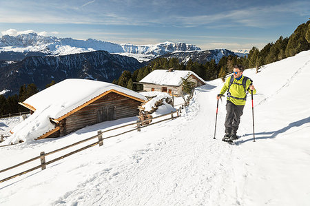 simsearch:879-09190638,k - a hiker is walking with snowshoes in Val Gardena with two typical mountain huts in the background, Bolzano province, South Tyrol, Trentino Alto Adige, Italy Fotografie stock - Rights-Managed, Codice: 879-09190464