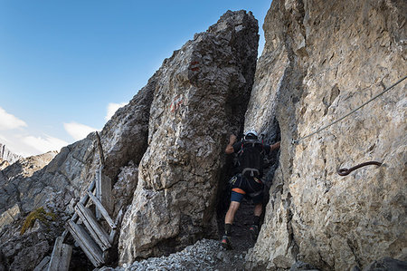 subiendo - a climber is passing through the rocks along the via ferrata Bepi Zac on the battlefront of the World War One, Trento Province, Trentino Alto Adige, Italy Foto de stock - Con derechos protegidos, Código: 879-09190542