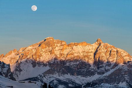 Gardena Pass, Alta Badia, province of Bolzano, South Tyrol, Italy, Europe. While the rocks of the Lavarella and Conturines glow in the sunset, the full moon rises Stockbilder - Lizenzpflichtiges, Bildnummer: 879-09190651