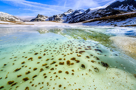 snow mountain lake - Turquoise water of Lake Andossi during thaw, Chiavenna Valley, Spluga Valley, Sondrio province, Valtellina, Lombardy, Italy Stock Photo - Rights-Managed, Code: 879-09191324