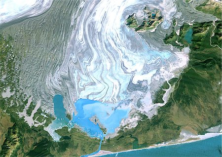 simsearch:872-06053023,k - Bering Glacier, Alaska, Usa, True Colour Satellite Image. Satellite image of the Bering Glacier, the largest glacier in North America. It currently terminates in Vitus Lake (South East on the picture), about 10km from the Gulf of Alaska, and flows into the sea through a small outlet. The glacier is bordered by gray moraines. Image taken on 25 September 1986 using LANDSAT data. Fotografie stock - Rights-Managed, Codice: 872-06053005