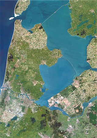 satellite view city - Polders, Netherlands, True Colour Satellite Image. Polders in the Netherlands, true colour satellite image. Polders are land reclaimed from the sea, using dikes and dunes, that are drained to expand the Dutch territory and for use as farmland. Image taken on 1 July 1994 using LANDSAT data. Stock Photo - Rights-Managed, Code: 872-06053039