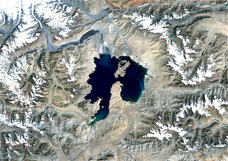 simsearch:872-06053081,k - Cratère d'Impact de météore de Kara-Kul, Tadjikistan, True Image Satellite en couleurs. Image satellite de véritable couleur de la structure d'impact de Kara-Kul, Tadjikistan (âge : 25 millions d'années ; diamètre : 52 km). Image prise le 27 septembre 1992, à l'aide de données LANDSAT. Photographie de stock - Rights-Managed, Code: 872-06053125