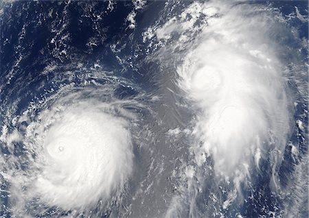 severe - Typhoon Mawar And Tropical Cyclone Guchol, Western Pacific, In 2005, True Colour Satellite Image. Typhon Mawar (left) and Tropical Cyclone Guchol (right) on 22 August 2005, far out in the northwestern Pacific Ocean, some 900 kilometers from Tokyo. True-colour satellite image using MODIS data. Stock Photo - Rights-Managed, Code: 872-06053869